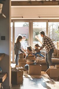 Family interacting with professional movers in a bright living room, showcasing trust and reliability